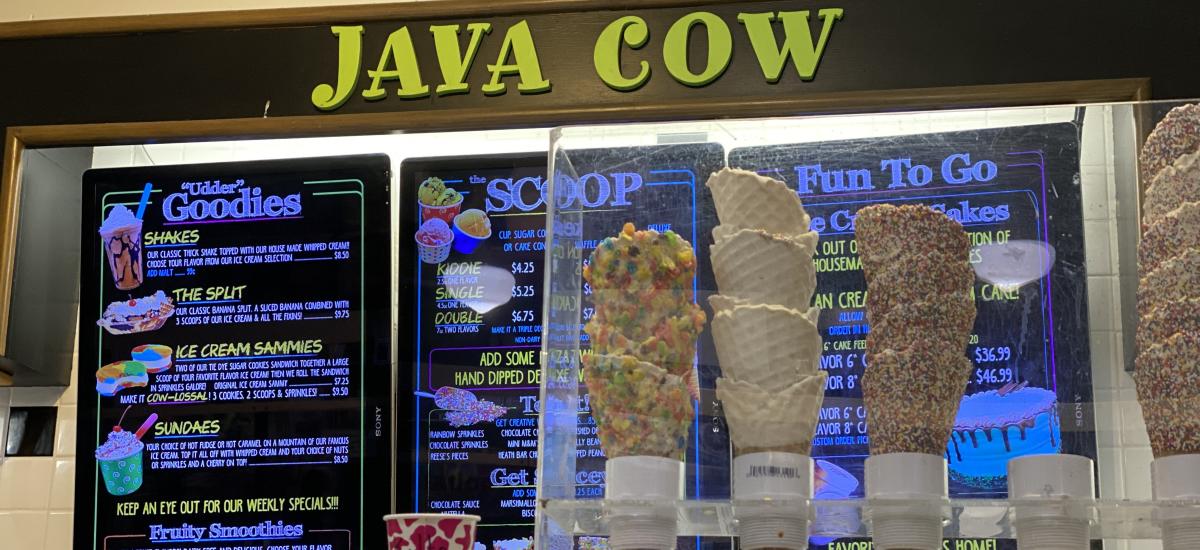 Waffle cones in front of Java Cow sign and menu