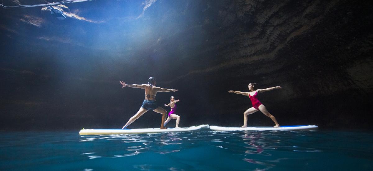Three women doing yoga on stand up paddleboards