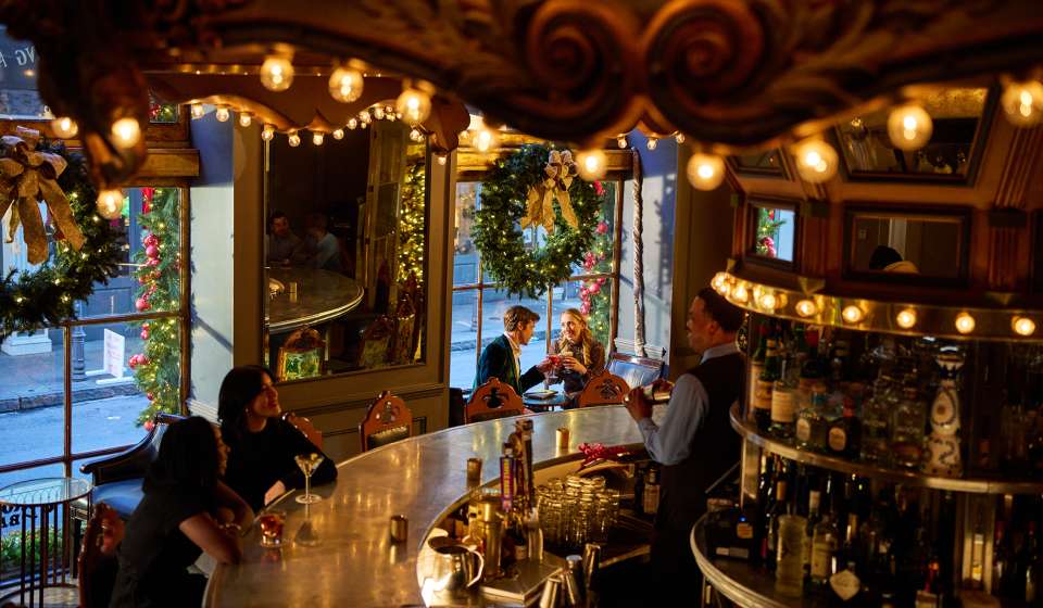 A couple enjoys holiday cocktails in the festive environment of the Carousel Bar in Hotel Monteleone.