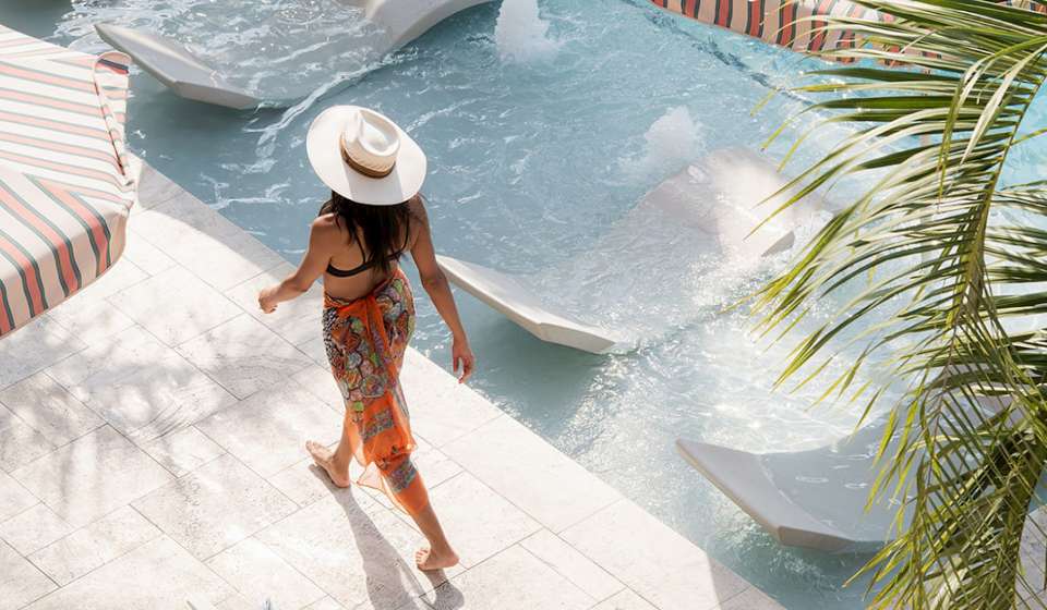 A woman walks by the pool at the Garden District Hotel in New Orleans