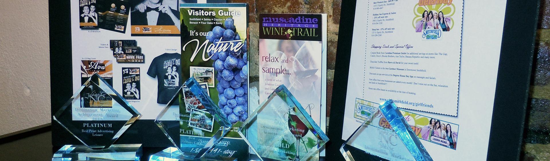 A display of Johnston County Visitors Bureau marketing samples with awards won in front of them.