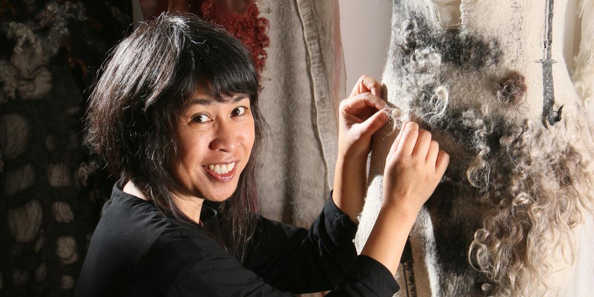 Designer Celeste Malvar-Stewart works on a dress made of sustainable fabrics