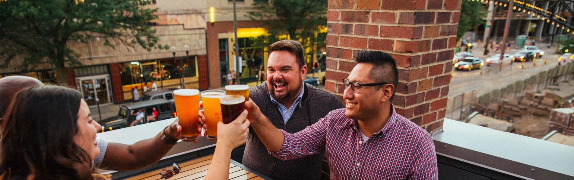 Friends clinking beer glasses at brewery