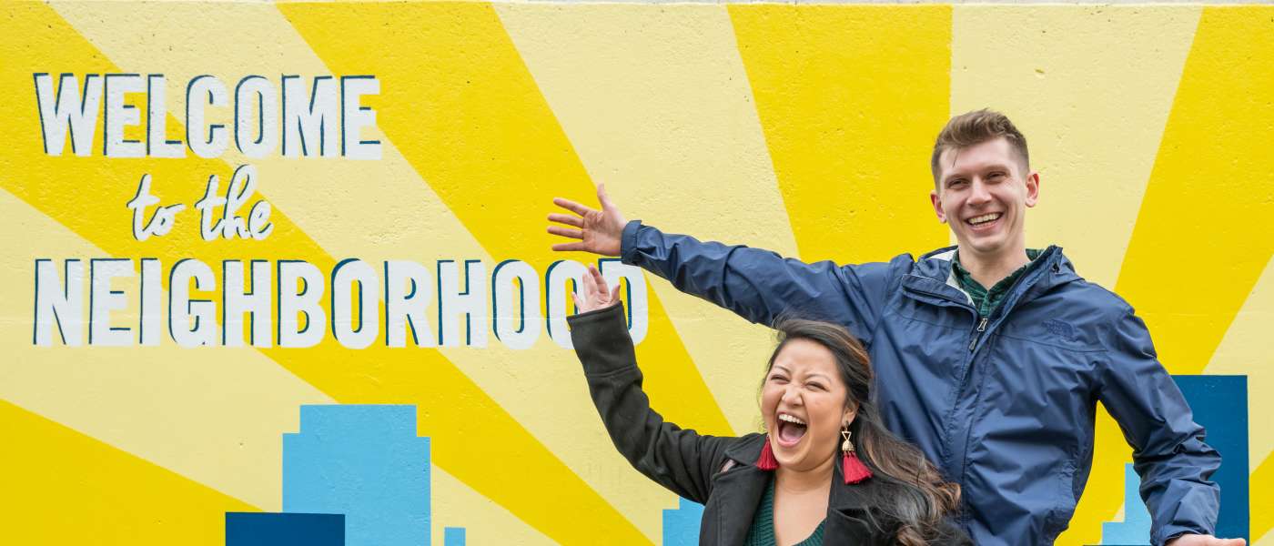 Couple enjoys the Welcome to the Neighborhood mural in the Vista Greenway.