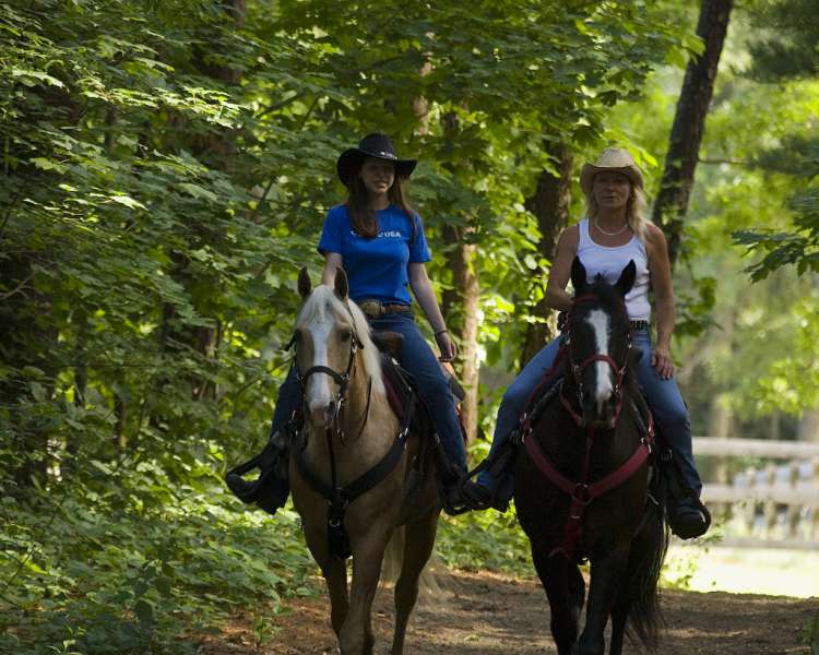 Two women (C&L Stables) riding horses on trails at Goddard Park. Location may be listed as East Greenwich or Warwick.