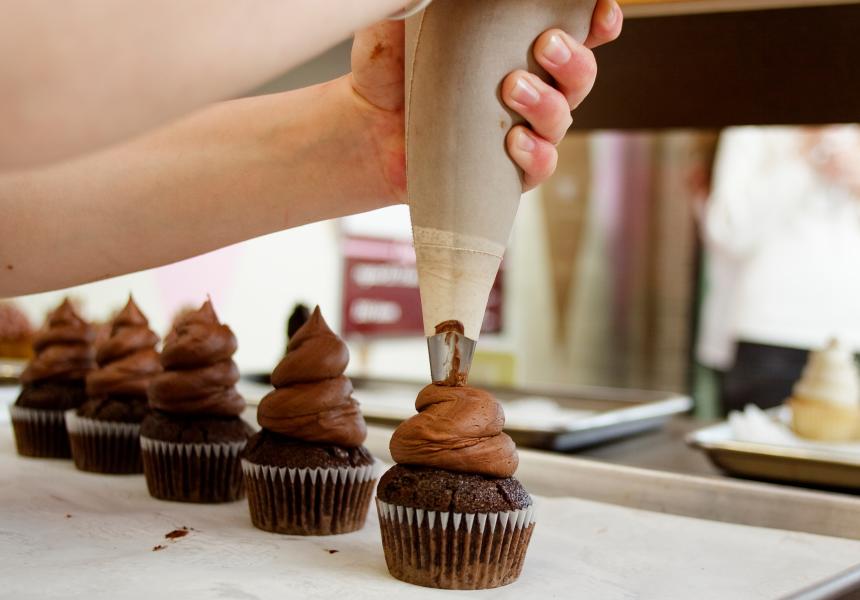 Piping frosting onto cupcakes