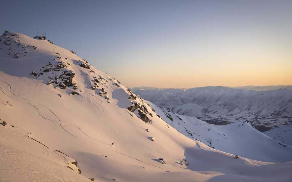 Far shot of person skiing at the Remarkables ski aera at sunrise