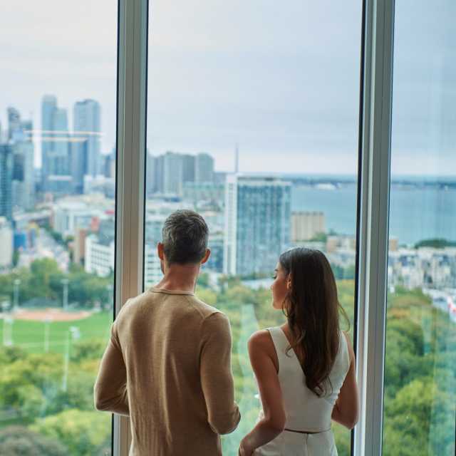 A couple looks out at the Toronto skyline from Hotel X