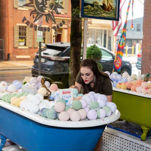 Woman leaning over collection of bath bombs