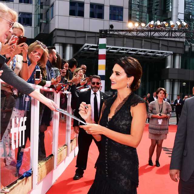 Penelope Cruz signing autographs for a fan on the red carpet at TIFF
