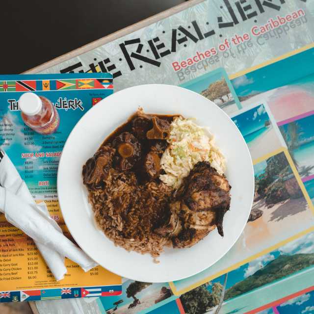 Plated dish atop a menu at The Real Jerk Restaurant in Toronto