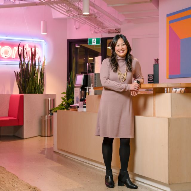 Eva Wong standing at Borrowell office with Toronto neon sign in background