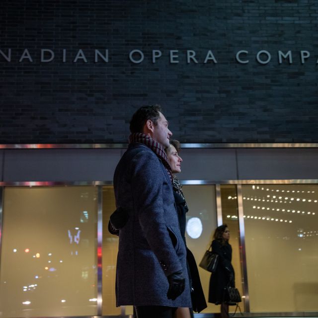 A couple walks outside Canadian Opera Company, Four Seasons Centre for the Performing Arts