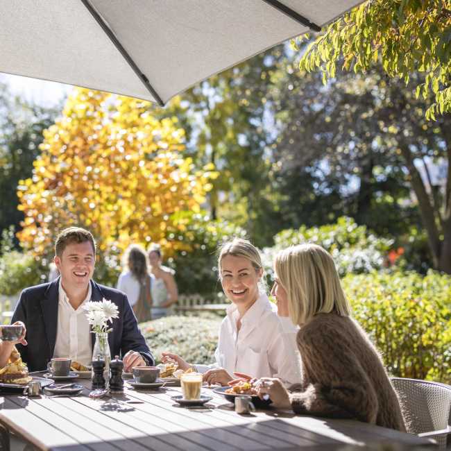 Group of people enjoying breakfast outside on a sunny autumn day