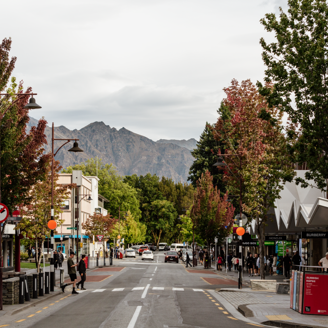 Queenstown town road with colourful trees and mountain in the background