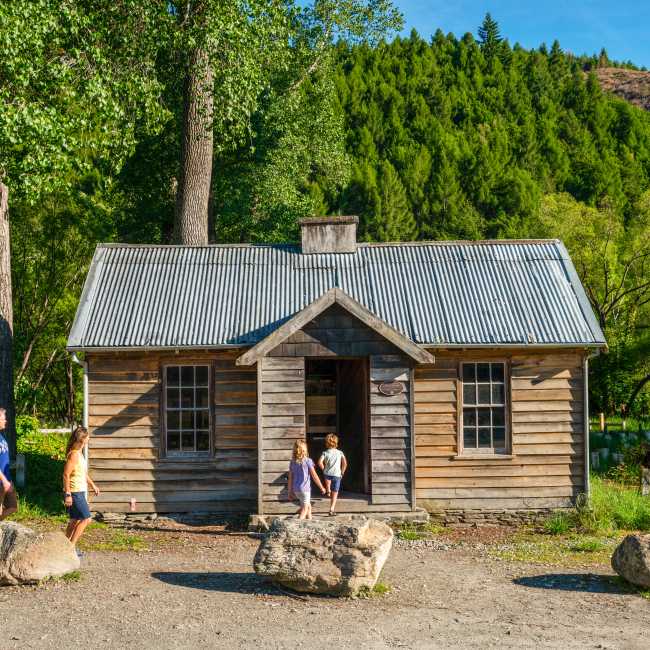 Family in front of the historic Arrowtown Police Hut