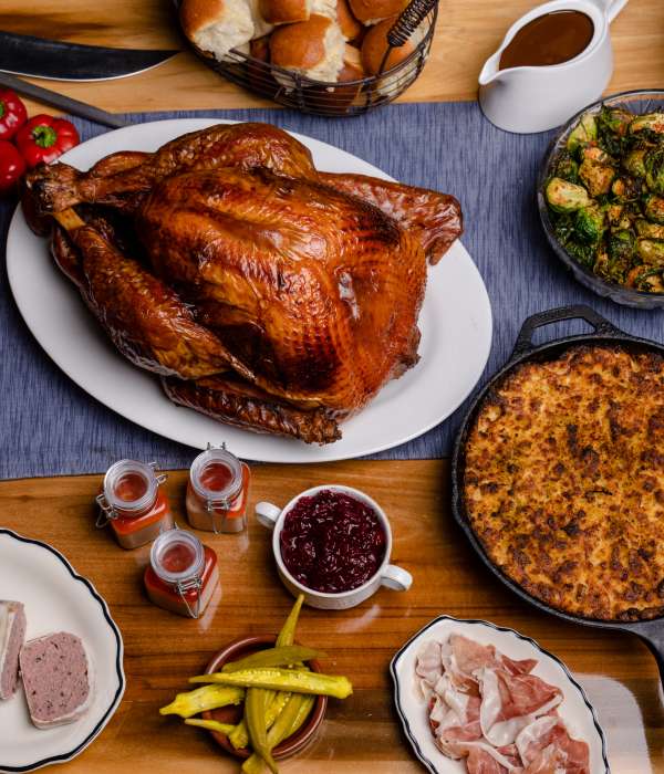 A Thanksgiving feast on wooden table including turkey and sides