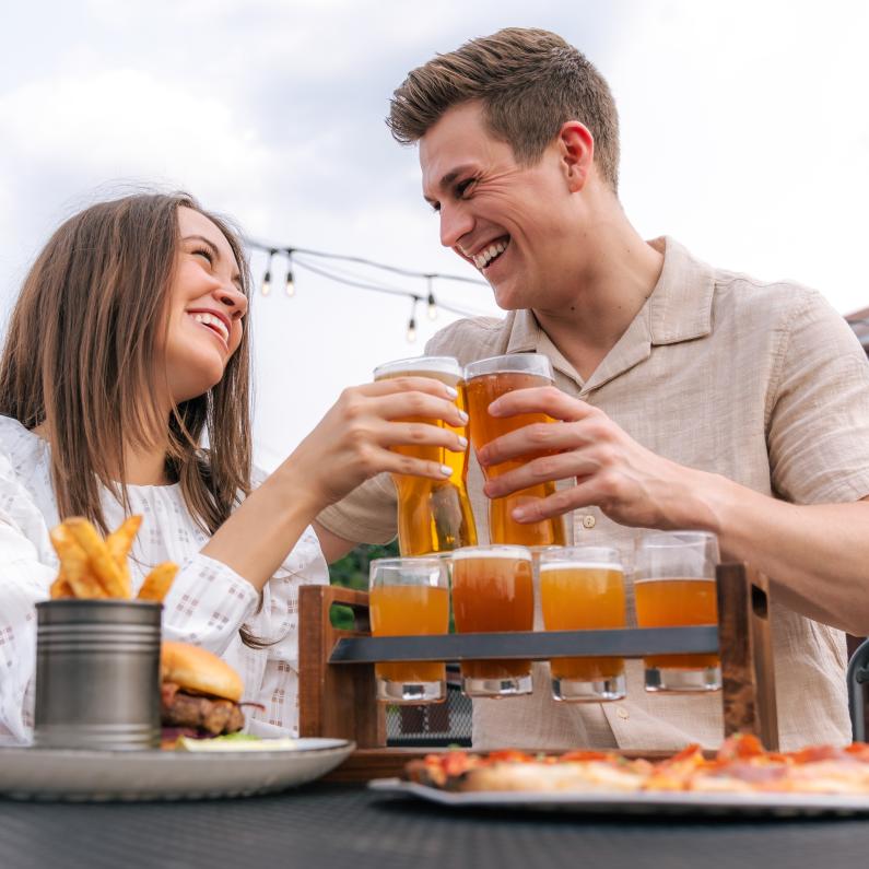 Couple doing a cheers with beer glasses at Grateful Goat.
