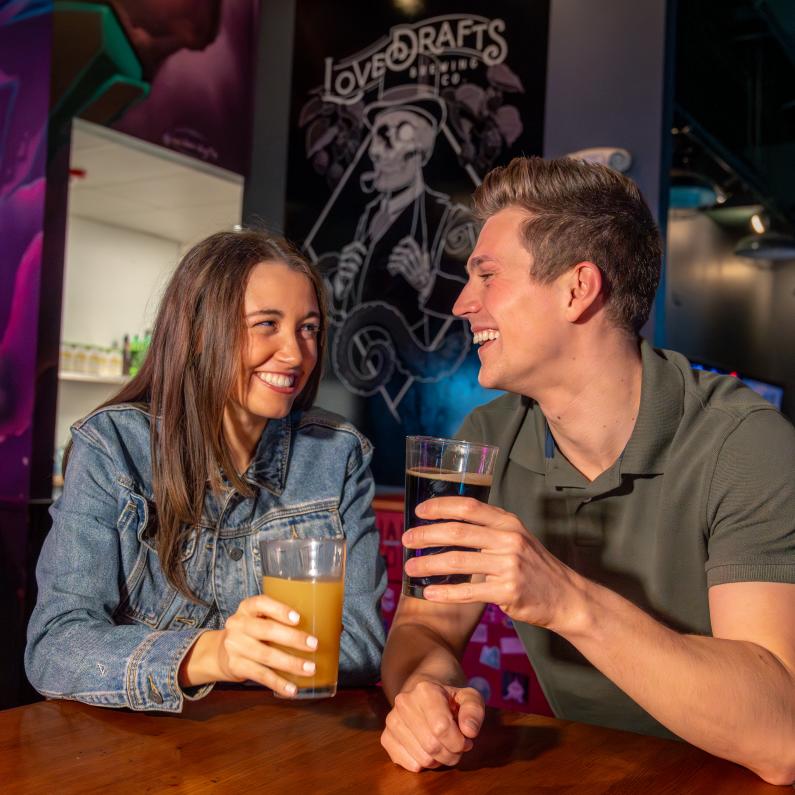 Couple enjoying draft beer and food at Lovedraft's