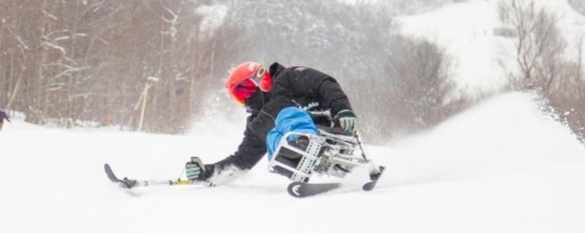 An adaptive skier in action on a snow-covered slope on Whiteface Mountain