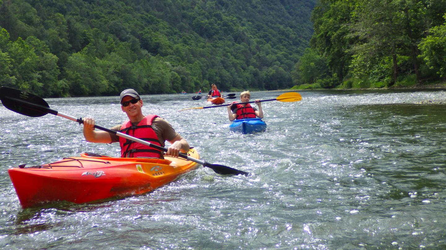 people kayaking down a river