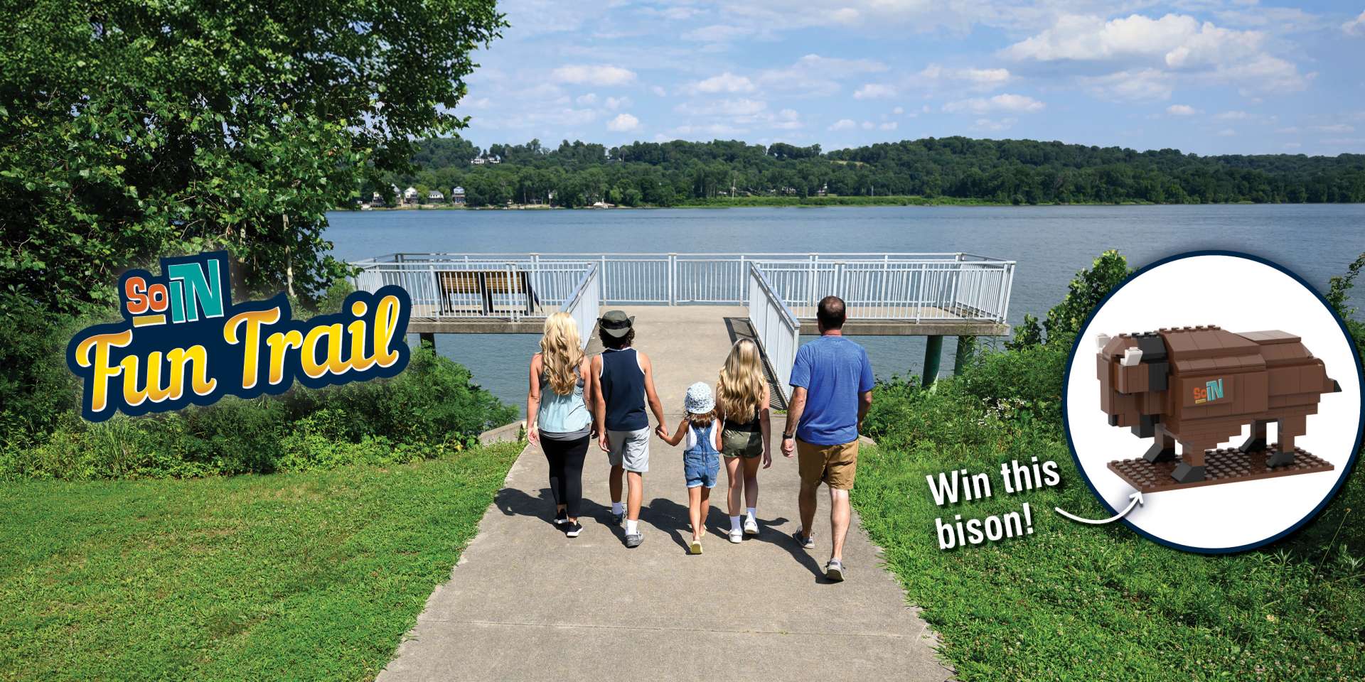 Family walking down a riverside path toward an overlook on the Ohio River as part of the SoIN Fun Trail, with a graphic promoting a buildable bison prize.
