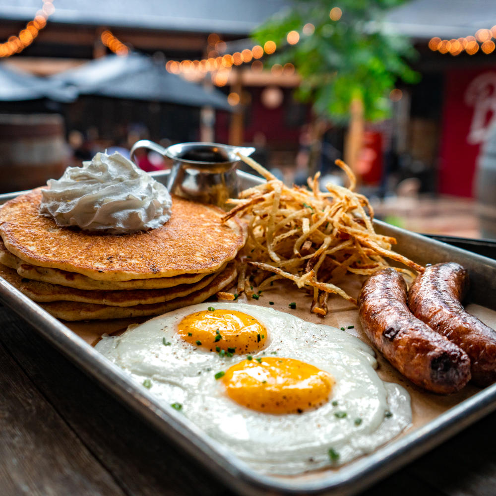 Image of a plate from Banger's with pancakes, eggs, sausage and hash browns.