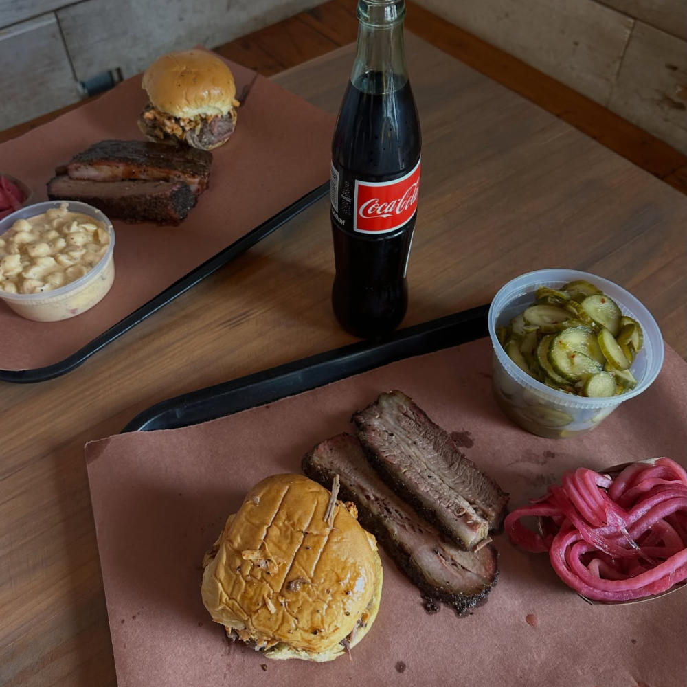 Photo of a tray of barbecue and a glass bottle coke sitting on a table at la Barbecue.