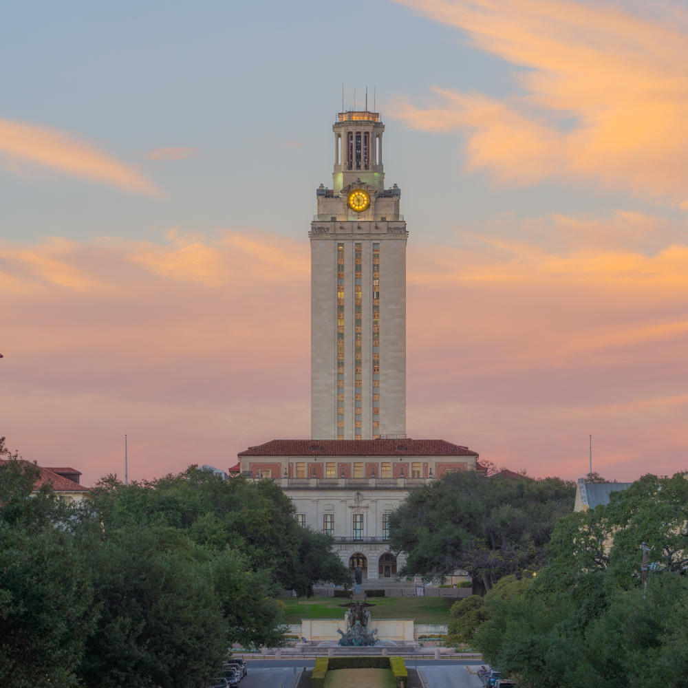 Sun setting behind the iconic UT Tower at the University of Texas at Austin.