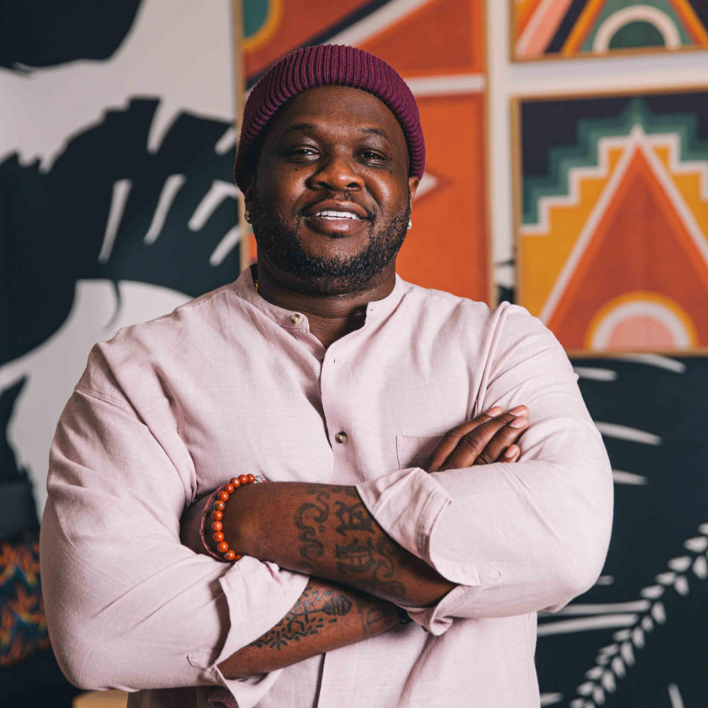 Chef Tavel Bristol-Joseph smiling with his arms crossed inside of Canje.