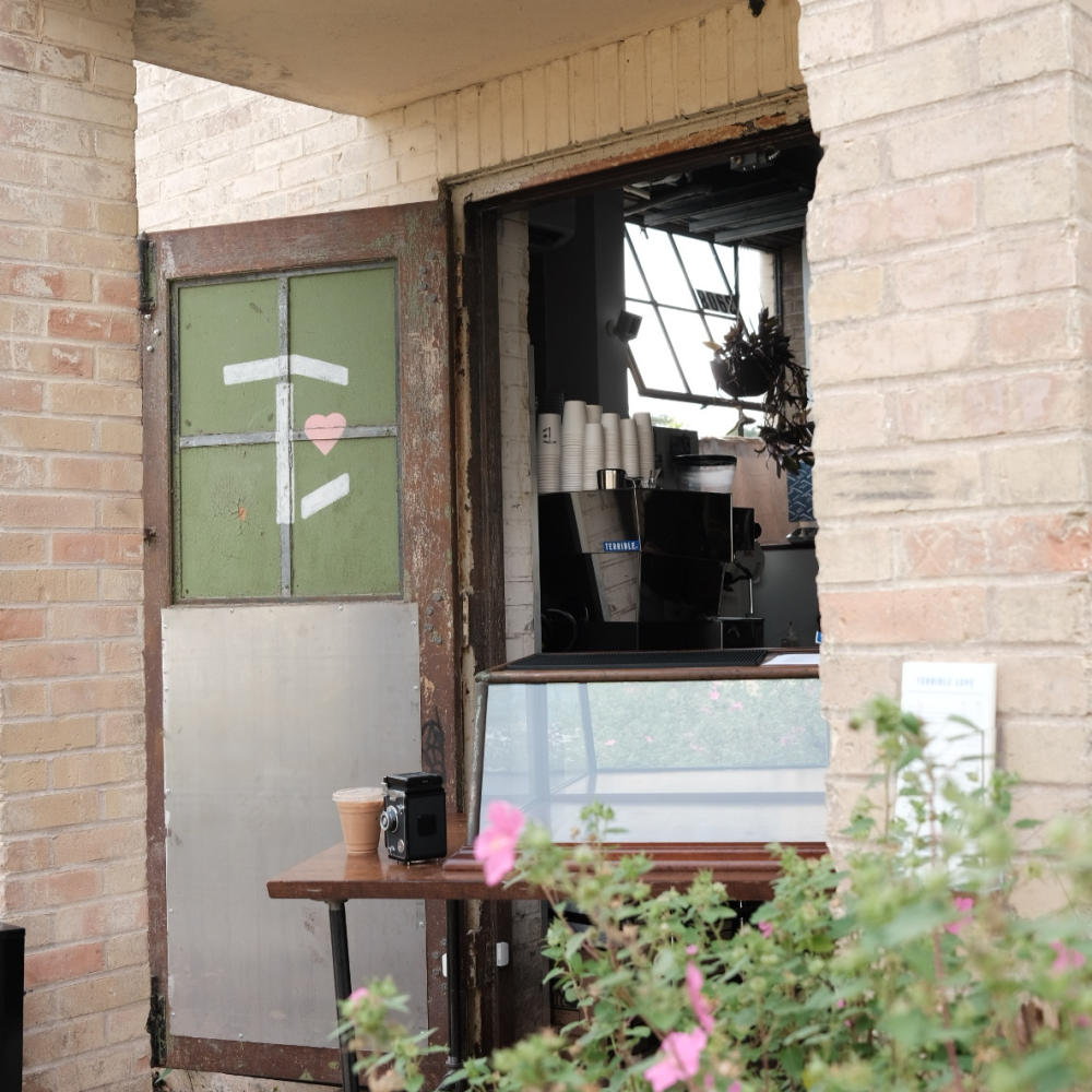 The brick walk-up window where you order coffee at Terrible Love.