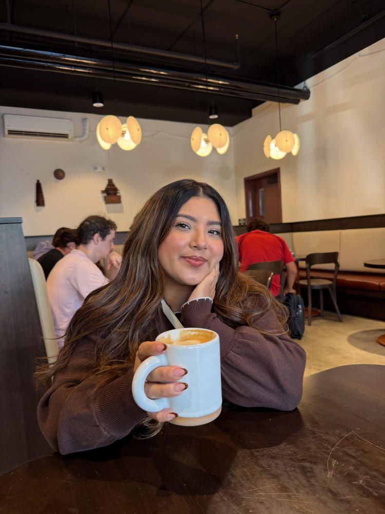 Erika Franco holds up a coffee mug at Factory Coffee in Downtown Kalamazoo.