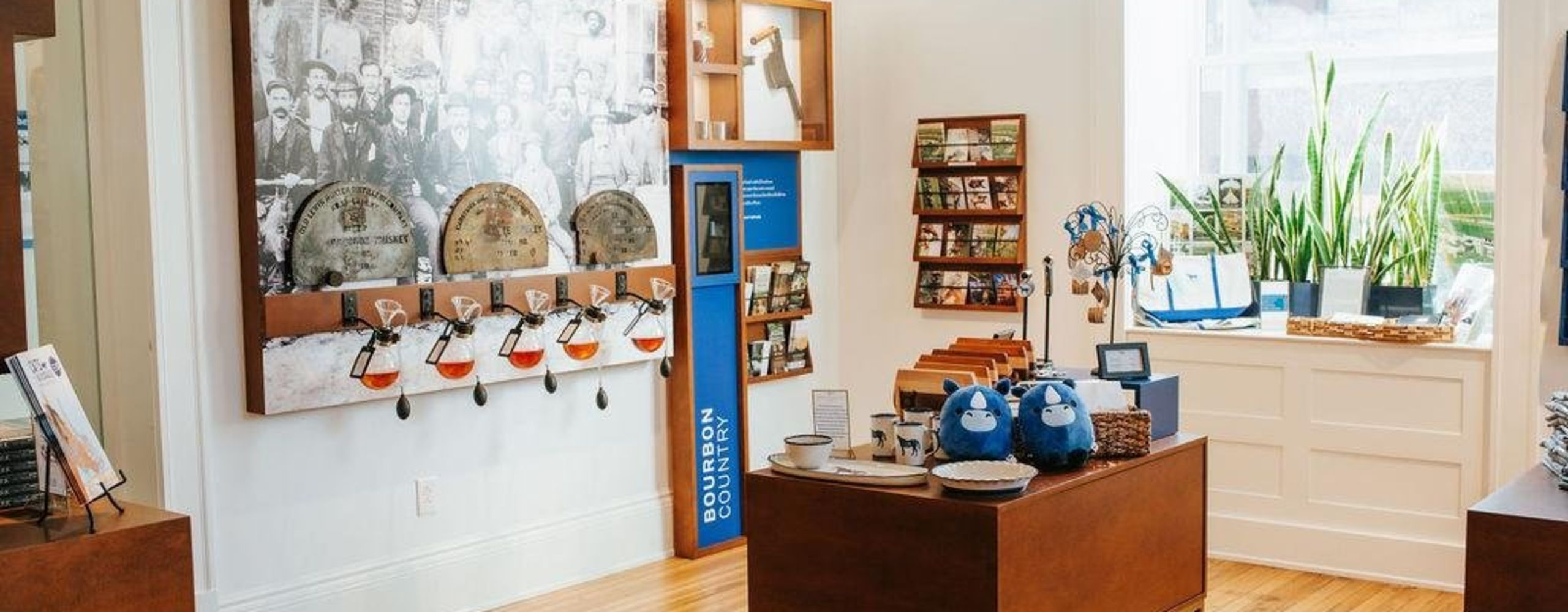 Gift shop with table of merchandise and a wall of bourbon snifters