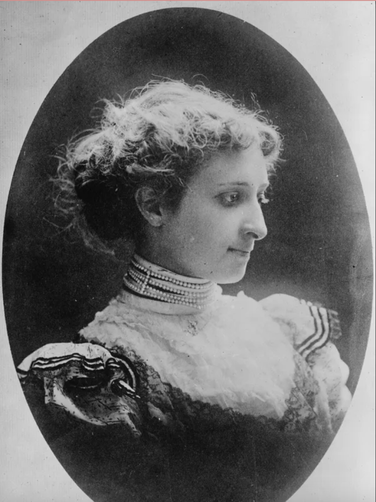 An antique photo of a woman in profile. She's looking to the right with a slight smile.