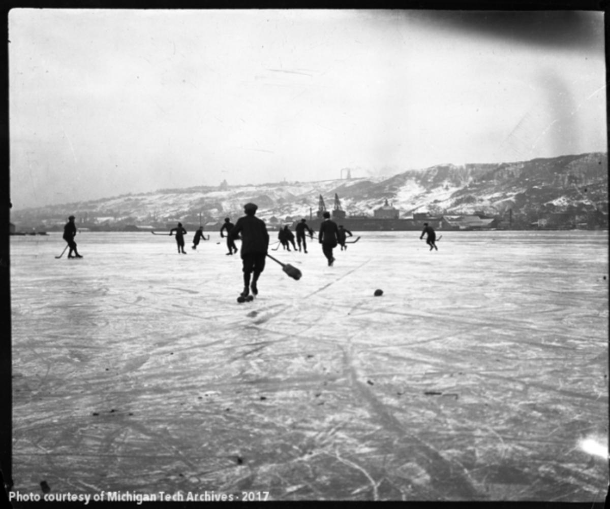 Group playing hockey on the Portage Canal in 1914