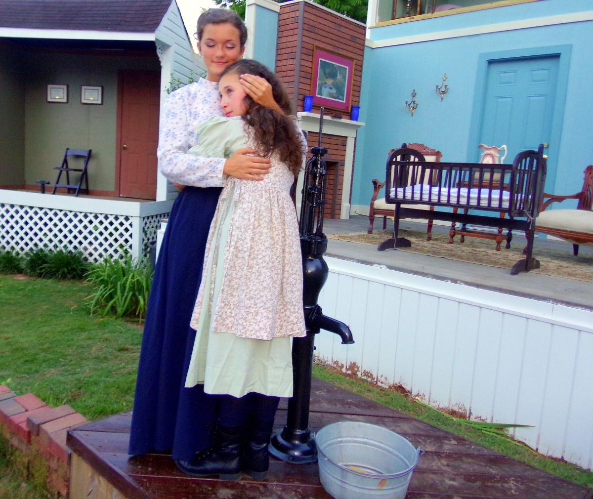 The Miracle Worker Play at Ivy Green - Helen Keller's Birthplace in Tuscumbia. Anne Sullivan embraces a young Helen Keller during a scene of the play.
