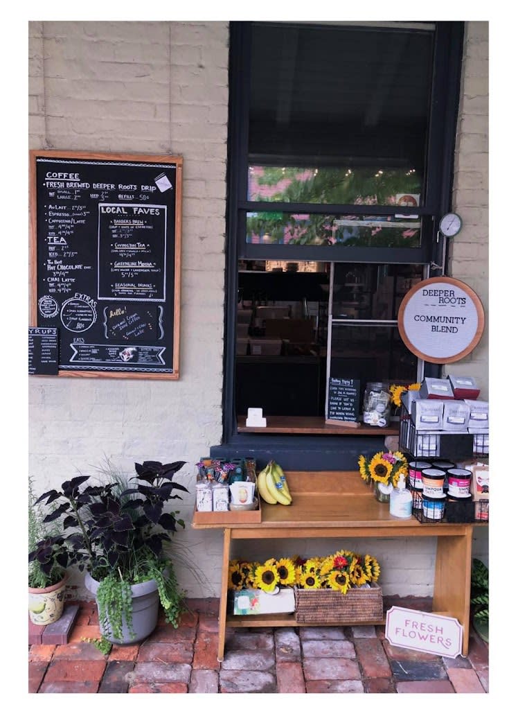 Image is of the outside, walk-up window of the coffee shop with a chalkboard menu on the left of the window.