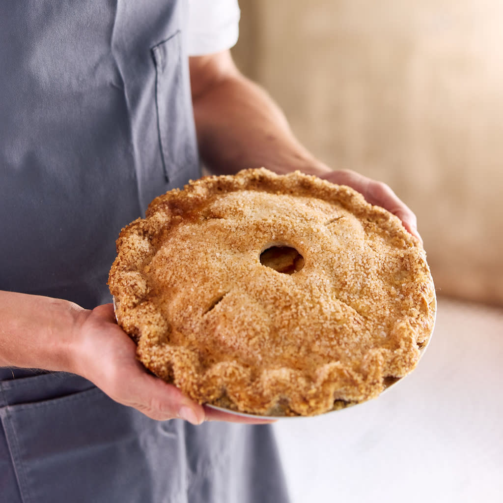 Baker holding a pie.
