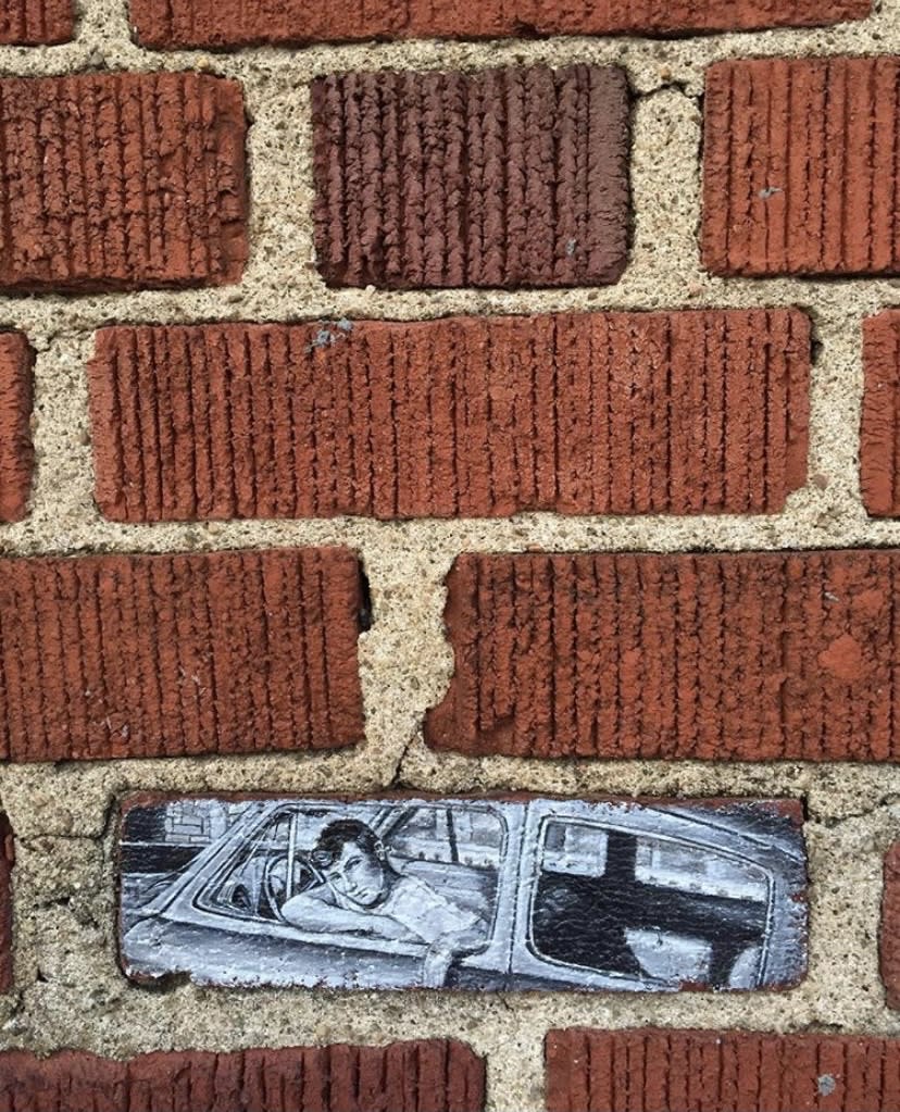 Brick painting of a man in a car by Mandi Caskey