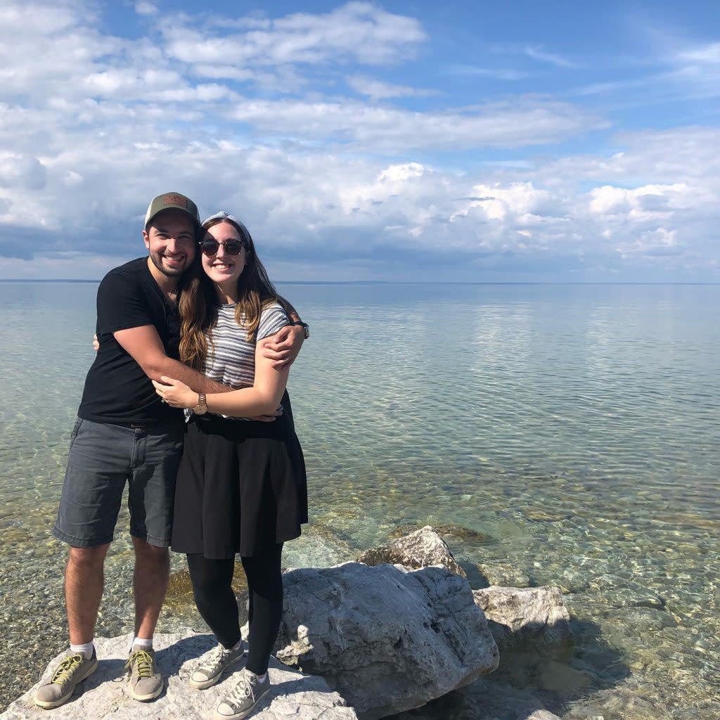 Couple Posing For Photo on Rock in Waters Surrounding Mackinac Island