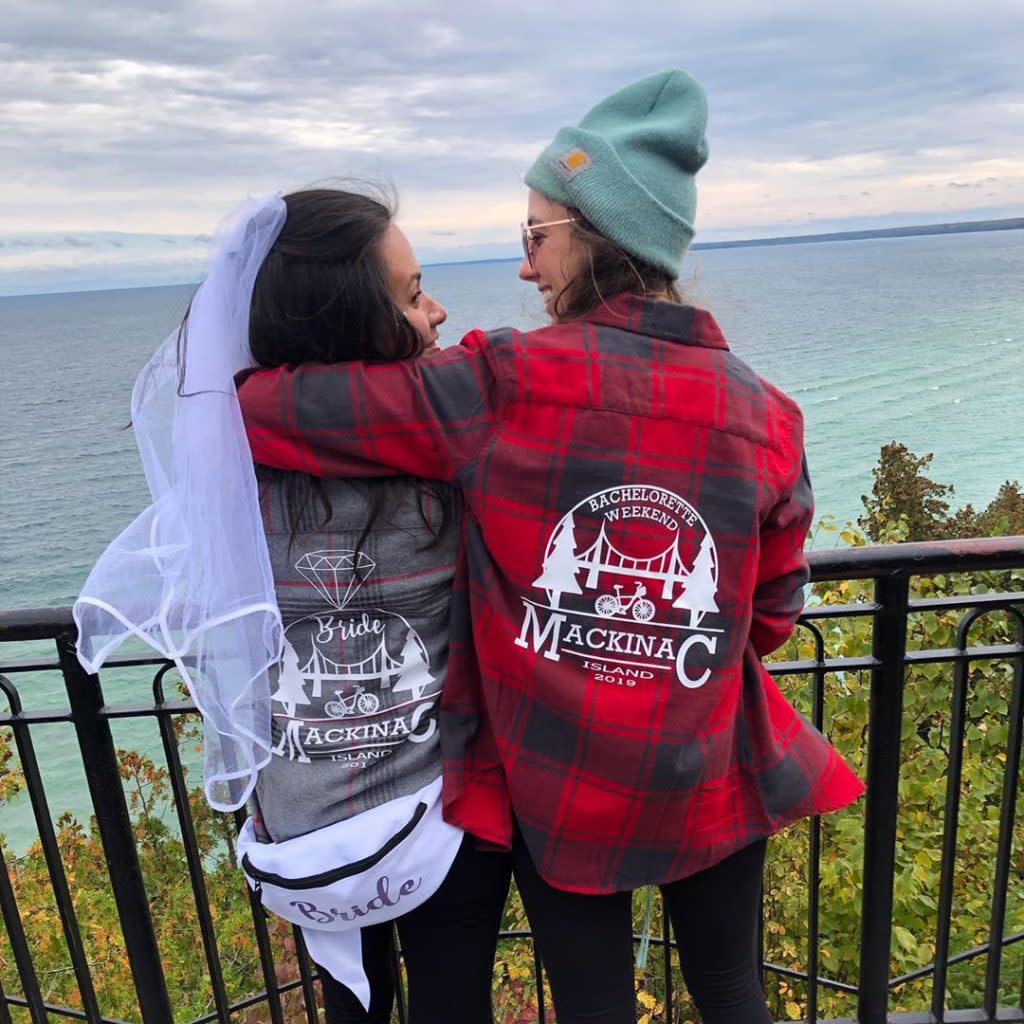 Bride and Bridesmaid Standing Together on Bachelorette Weekend Looking Out to Water Surrounding Mackinac Island