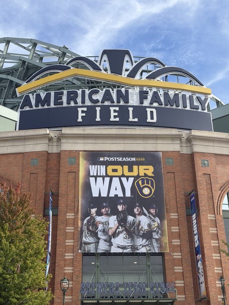 American Family Field exterior featuring a large Milwaukee Brewers 2026 postseason “Win Our Way” banner above the Brewers Team Store.