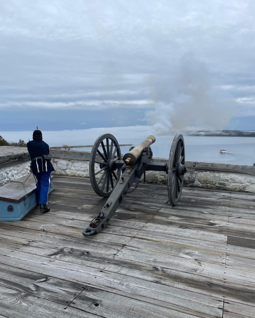A historical interpreter fires the cannon at Fort Mackinac for the first time in the 2022 season on Mackinac Island.