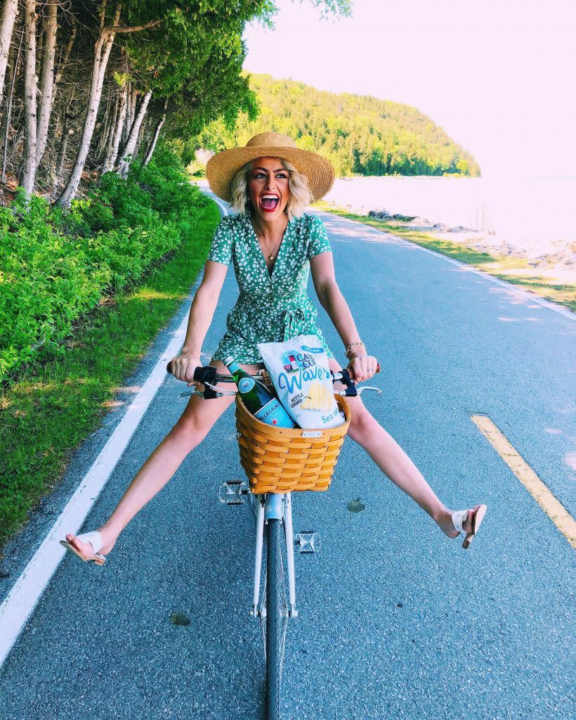 Woman Riding Bicycle with Basket of Snacks on Mackinac Island 