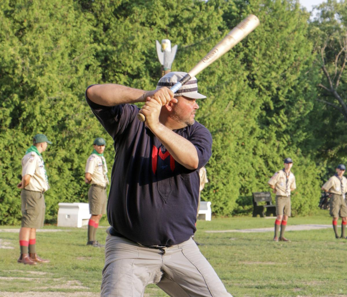 A member of the Fort Mackinac Never Sweats stands at the plate as Boy Scouts watch a vintage base ball game