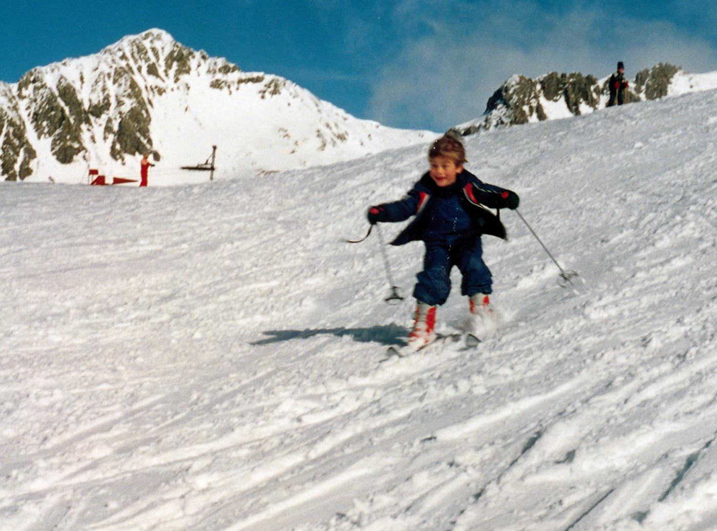 Small child skiing down snowy slopw
