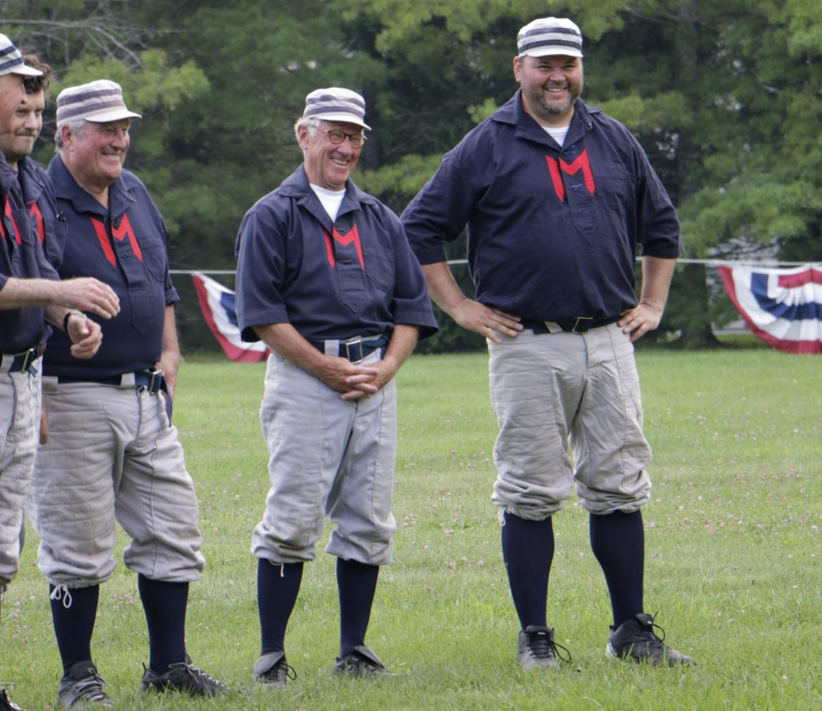 Members of the Fort Mackinac Never Sweats laugh before the start of a vintage base ball game on Mackinac Island