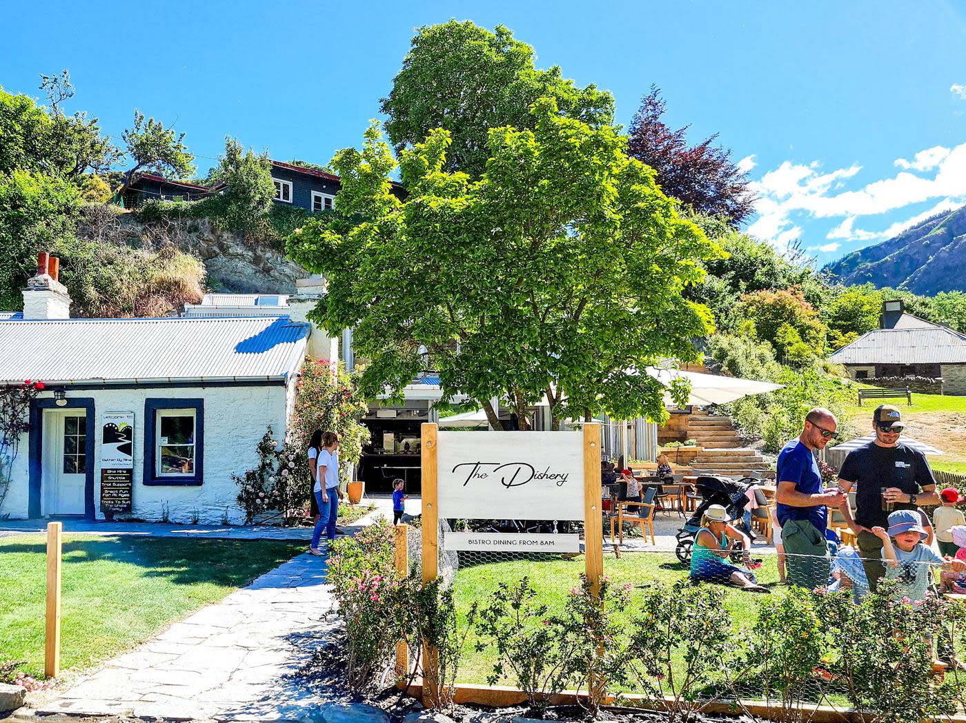 People hanging out on the lawn outside The Dishery cafe in Arrowtown in summer
