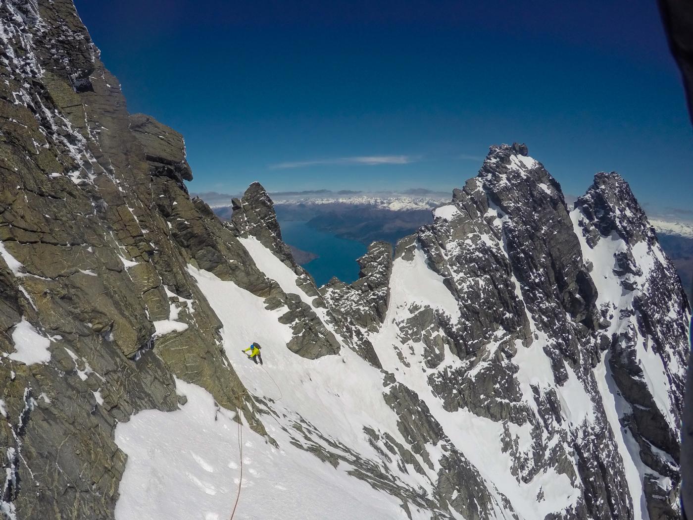 Wide shot showing person climbing a huge mountain