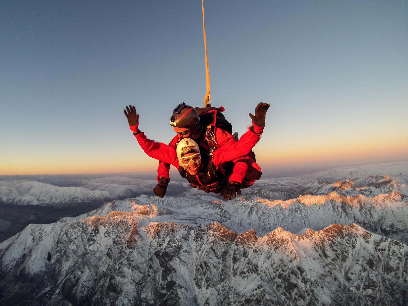Tandem skydiving over snowy mountains